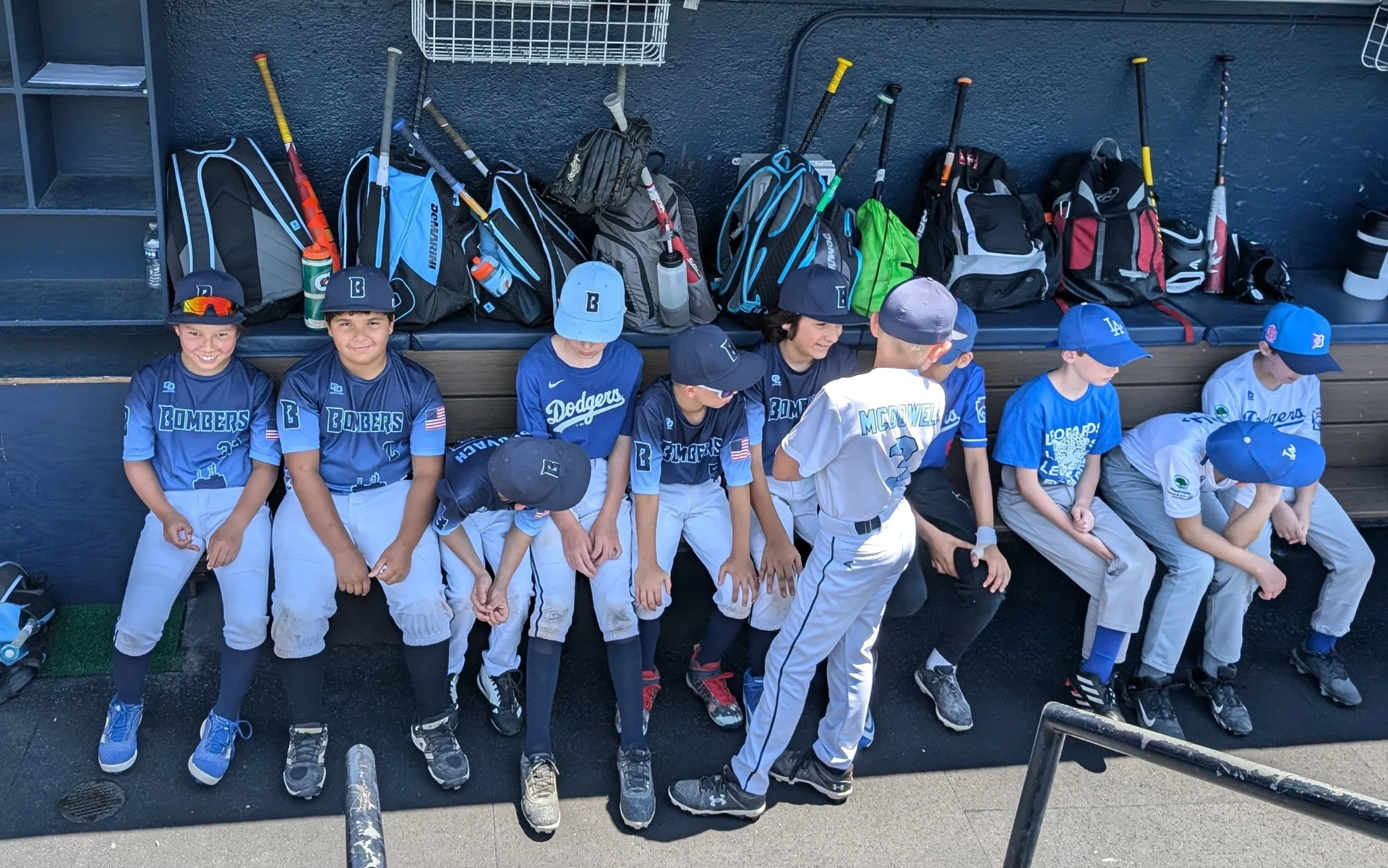 Bombers and visiting Little League players sitting side by side on the dugout bench between games